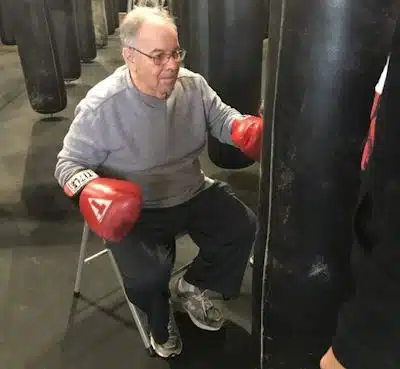 man rock steady boxing from a chair