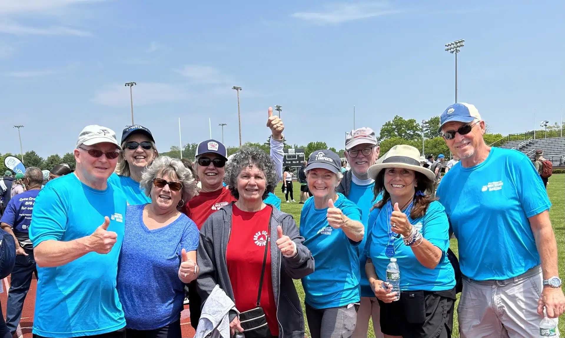 Walk participants have big smiles and give a big thumbs up on a sunny day.