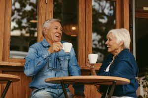 Portrait of senior couple sitting at table and drinking coffee in cafe.