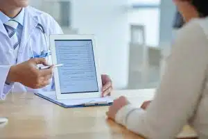 physician pointing at screen of digital tablet