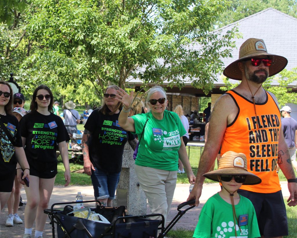 Older woman waving as she walks by during the Optimism Walk