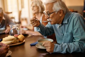 Senior man eating lunch at nursing home.