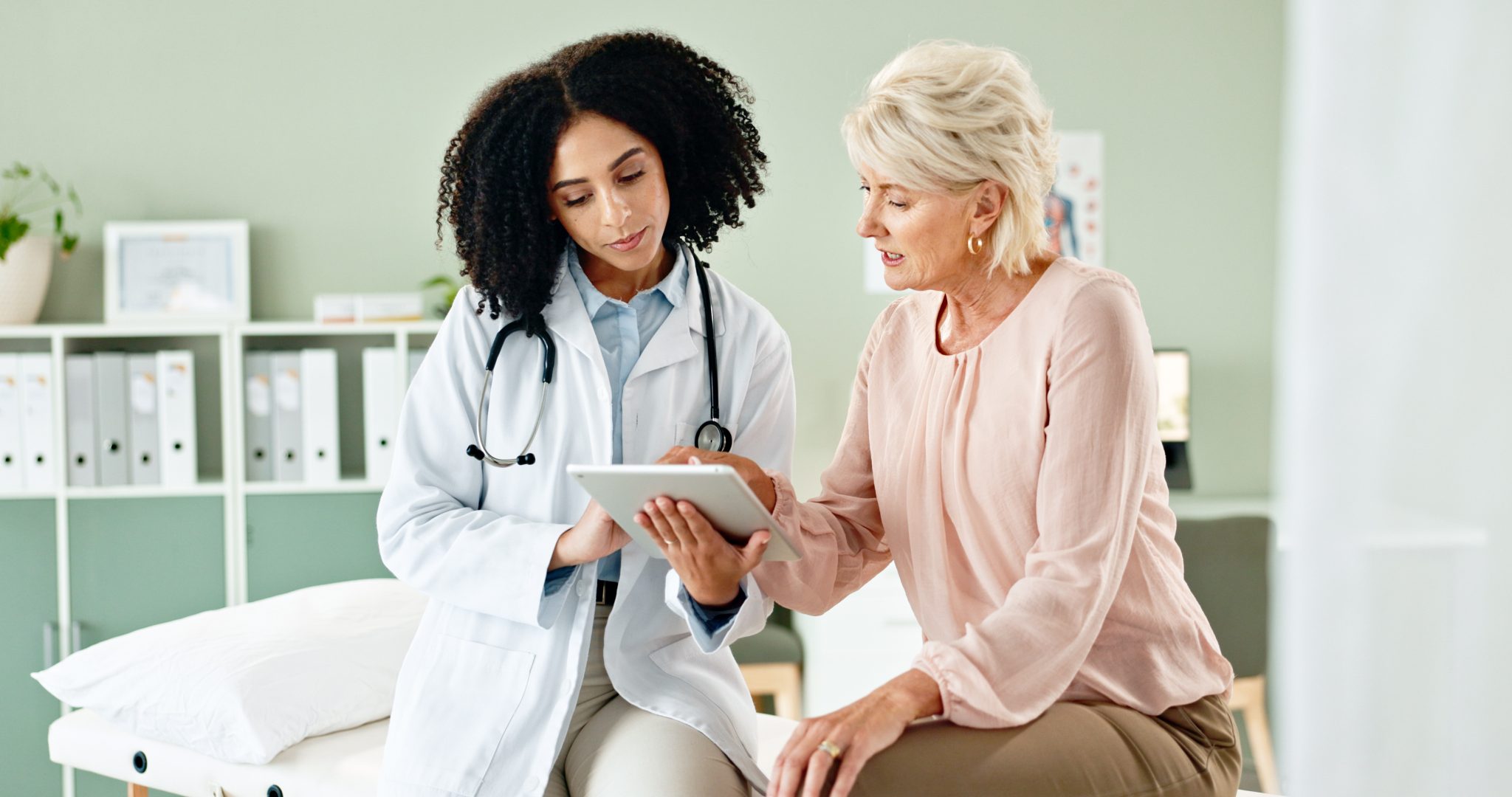 Hospital, tablet and doctor with mature patient for medical service, consulting and help in clinic. Healthcare, telehealth and woman and senior person on technology for diagnosis results or insurance.